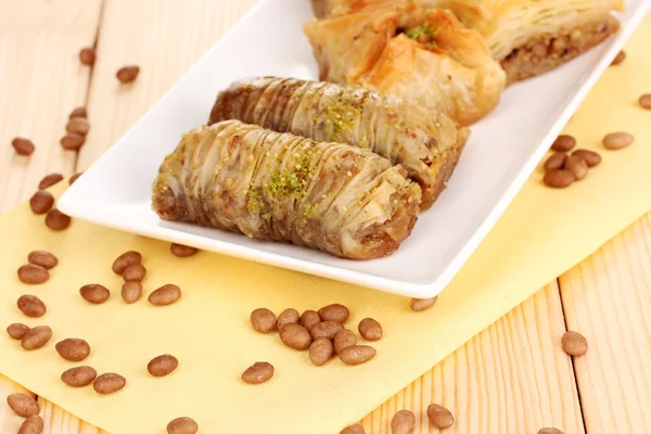 Sweet baklava on plate on wooden background — Stock Photo, Image