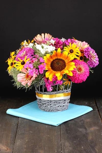 Красивый букет ярких цветов на деревянном столе на черном фоне — стоковое фото
