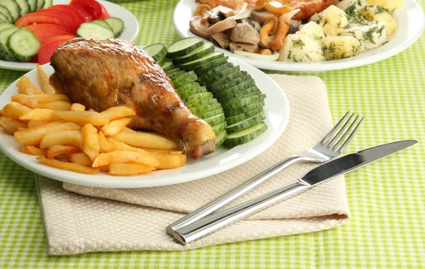 Roast chicken with french fries and vegetables, on green table cloth — Stock Photo, Image