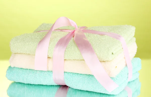 Kleurrijke handdoeken met lint op groene achtergrond — Stockfoto