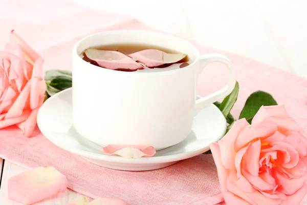 Xícara de chá com rosas na mesa de madeira branca — Fotografia de Stock