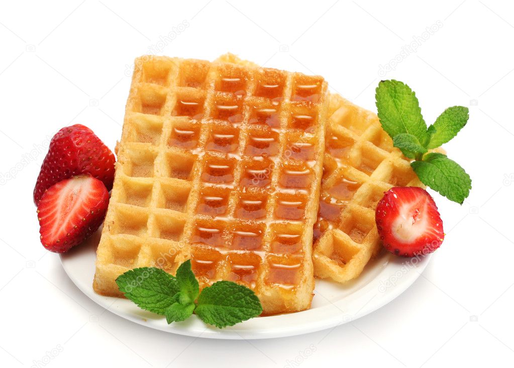 Belgium waffles with honey, strawberries and mint on plate isolated on white