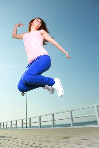 Attraktive Mädchen junge Frau springen Himmel — Stockfoto