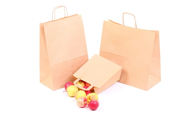 Покупка коричневых подарочных пакетов и яблоко изолированы — стоковое фото