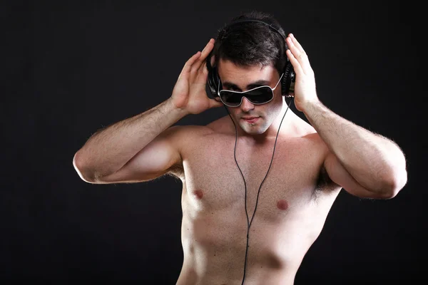 Bonito homem ouvindo música no fone de ouvido — Fotografia de Stock