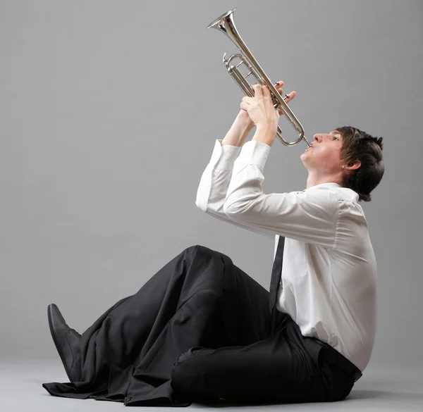 Портрет молодого человека, играющего на трубе — стоковое фото