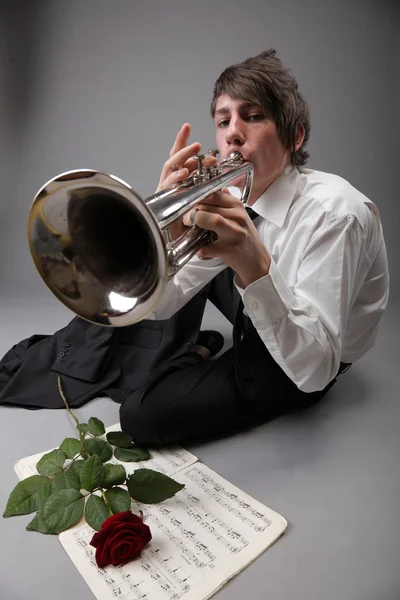 Retrato de um jovem tocando amor sua trombeta — Fotografia de Stock