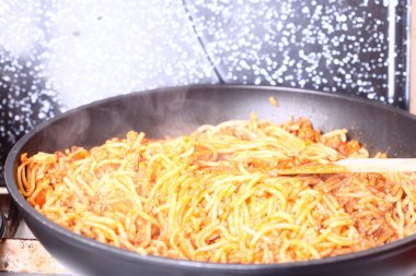 bir tavada spagetti makarna kaynıyor