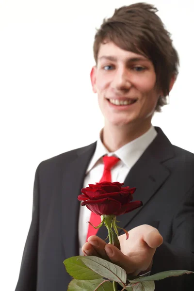 Jeune homme présentant une fleur rose rouge isolé — Photo