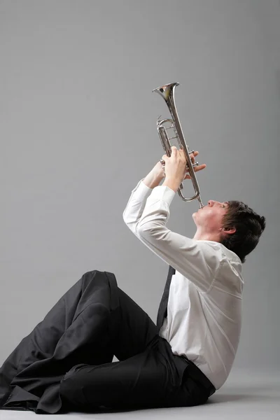 Портрет молодого чоловіка, який грає на трубі — стокове фото