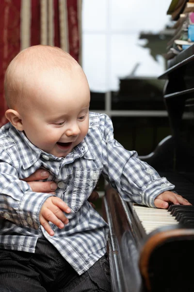 Mooie kleine babyjongen speelt piano — Stockfoto