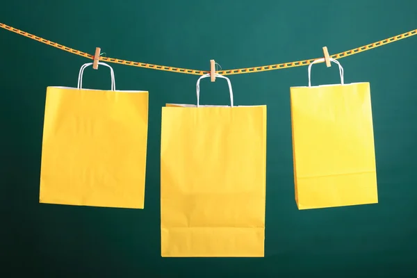Shopping yellow gift bags on green background — Stock Photo, Image