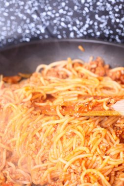 bir tavada spagetti makarna kaynıyor