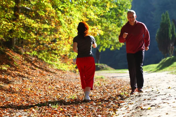 Mujer y hombre caminando a través del camino del campo en el bosque de otoño —  Fotos de Stock