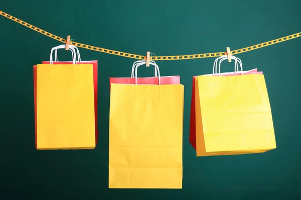 Compras bolsas de regalo amarillas sobre fondo verde —  Fotos de Stock