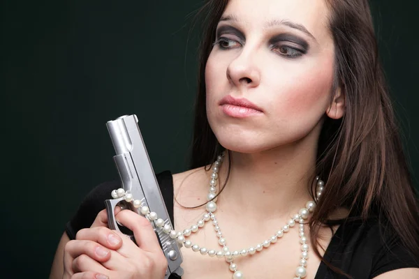 Sexy giovane donna capelli lunghi pistola amd perla — Foto Stock