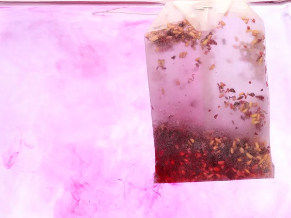 在热水中的红色袋泡茶 — 图库照片