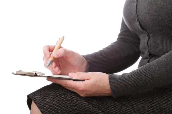 Una mujer escribe a pluma sobre papel. Aislado sobre fondo blanco — Foto de Stock