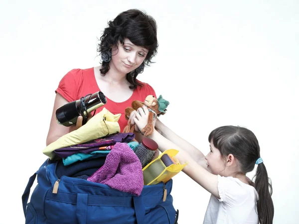 Vrouw en dochter hand vol vol kleren en schoudertas — Stockfoto
