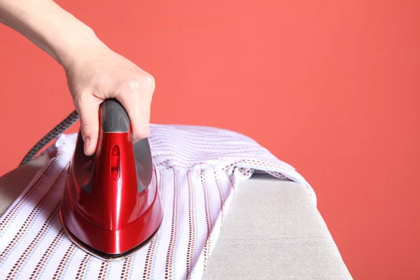 Rode ijzer in de hand en shirt — Stockfoto