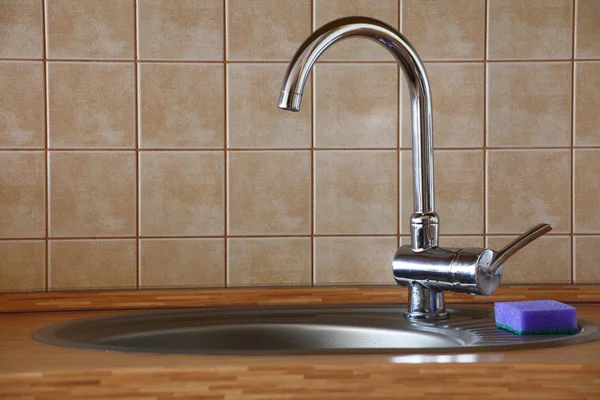Wasserhahn aus Chrom in einer Holzküche — Stockfoto