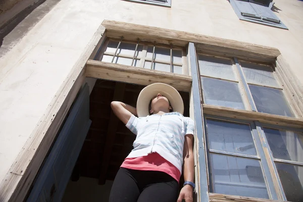 Mulher posando na abertura da janela — Fotografia de Stock