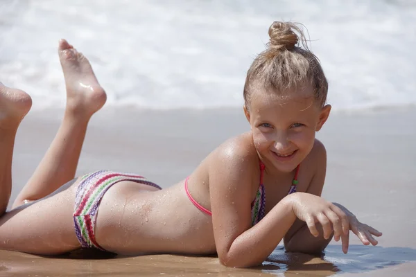 Blond meisje op het strand voor het looien — Stockfoto