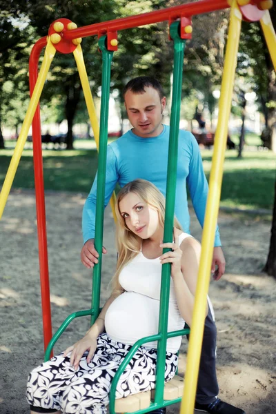 Papai se divertindo esposa grávida no parque durante — Fotografia de Stock