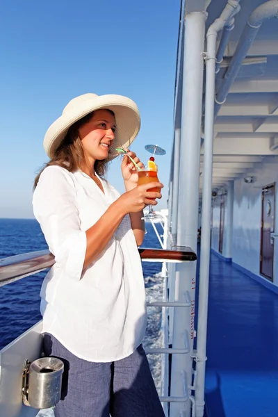 A woman sipping a cocktail happy traveling — Stock Photo, Image