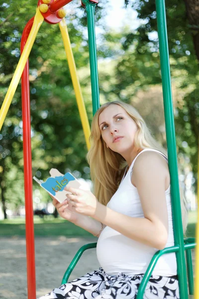 Zwangere meisje met een kinderboek — Stockfoto