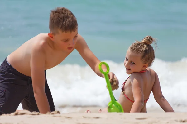 Crianças brincando na praia durante — Fotografia de Stock