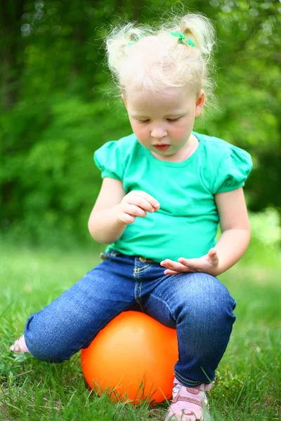 Retrato de uma menina sentada na bola — Fotografia de Stock