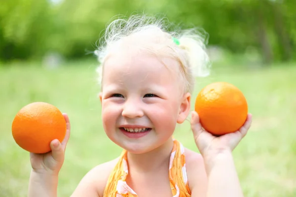 Retrato de menina rindo com laranjas — Fotografia de Stock