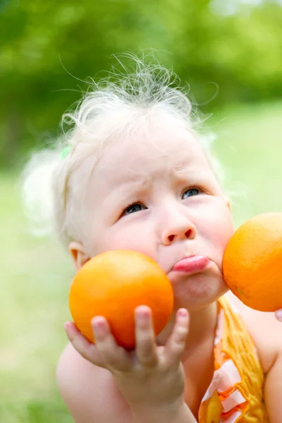 Retrato de uma menina frustrada com laranjas — Fotografia de Stock