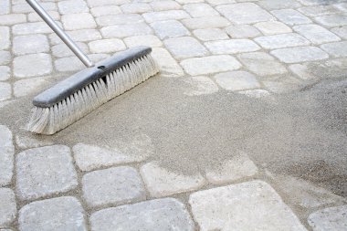 Broom Sweeping Sand into Pavers clipart