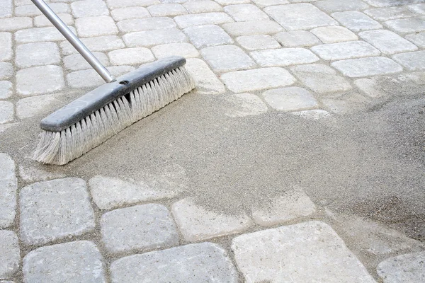 Broom Sweeping Sand into Pavers — Stock Photo, Image