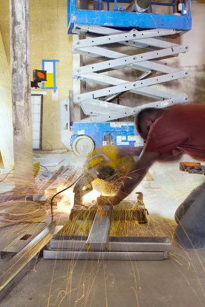 Bauarbeiter schneidet Metallstange mit Tischkreissäge — Stockfoto