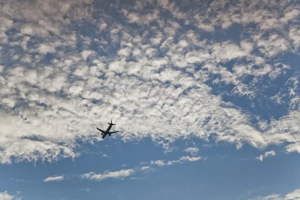 Облака, голубое небо и самолет — стоковое фото