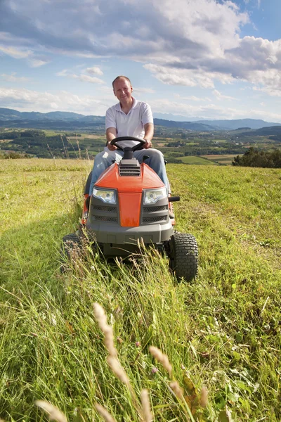 Homme chevauchant un tracteur de pelouse — Photo