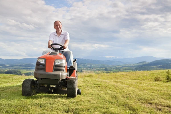 Homme chevauchant un tracteur de pelouse — Photo