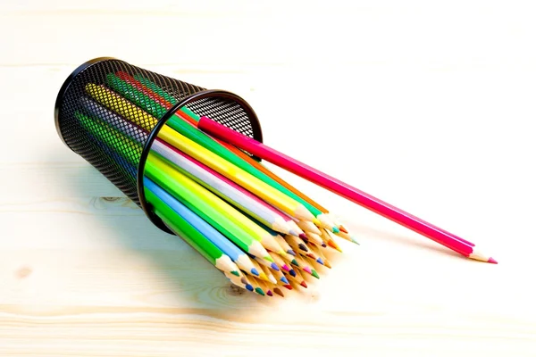 Colored pencils in a container on wood table — Stock Photo, Image