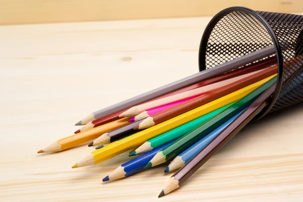 Colorful pencils in a container on wood table — Stock Photo, Image