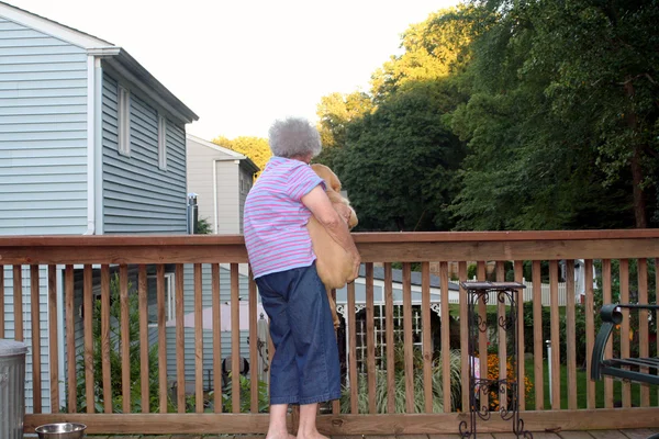 Mujer mayor sosteniendo cachorro horizontal — Foto de Stock