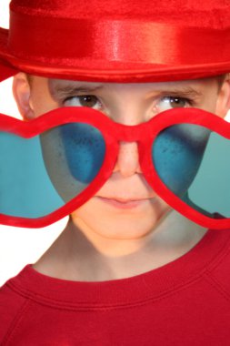 Boy Peeking Hesitantly Over Heart-Shaped Glasses clipart
