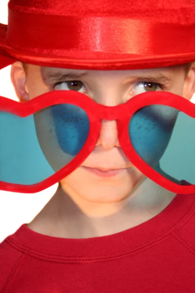 Boy Peeking Hesitantly Over Heart-Shaped Glasses — Stock Photo, Image