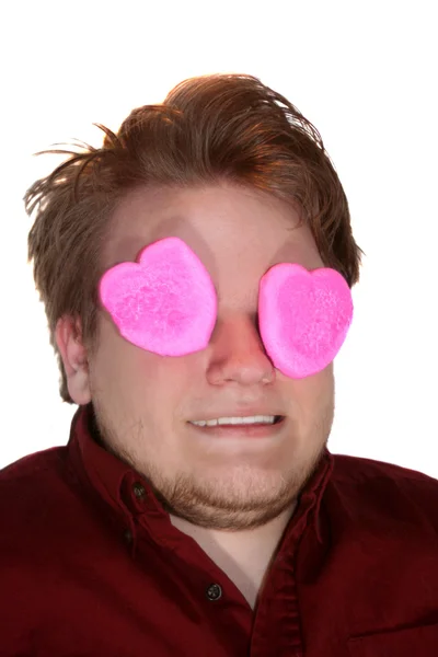Sorrindo adolescente menino com olhos cobertos por rosa Marshmallow corações — Fotografia de Stock