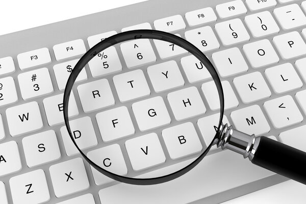 Magnifying glass with keyboard on a white background