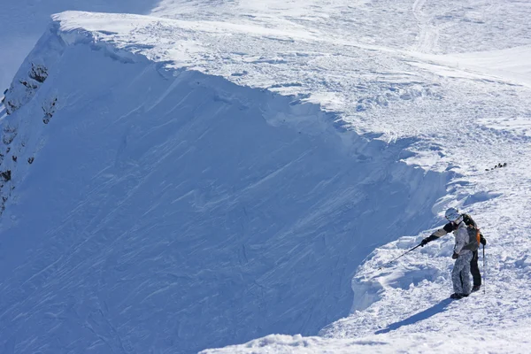 Ski freeriders on the brink of a precipice. — Stock Photo, Image