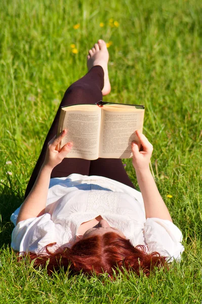 Vörös hajú szép lány Olvasson egy könyvet a természetben — Stock Fotó
