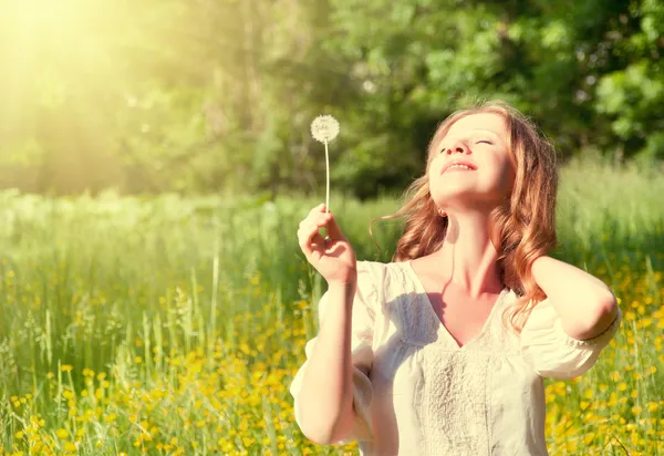 Beautiful girl with dandelion enjoying the summer sun — Stock Photo, Image